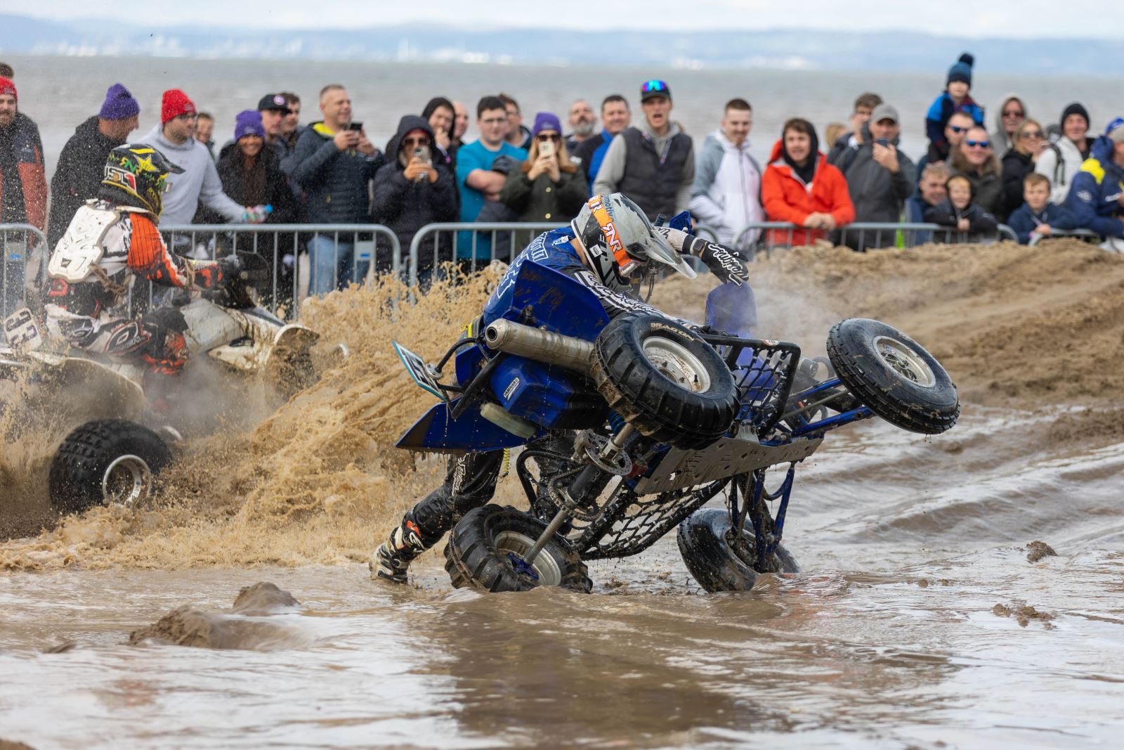 A quad bike rider wrestles with his machine to try and get it upright again at the Weston-super-Mare Beach Race