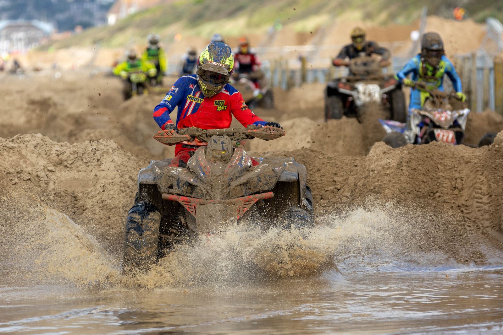 A quad biker splashes through a big puddle at the Weston-super-Mare Beach Race