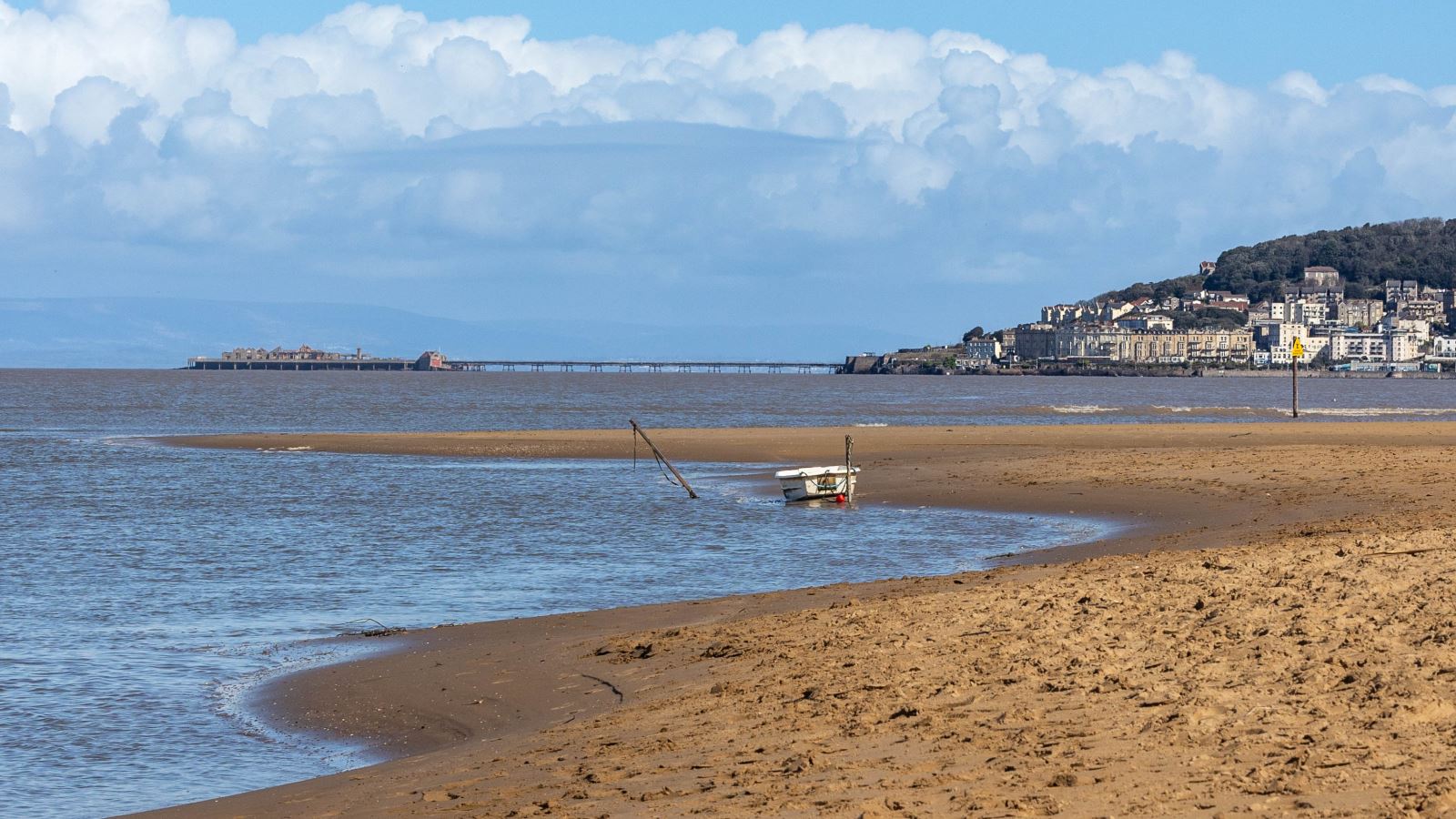 A small boat moored by the estuary on a sandy beach