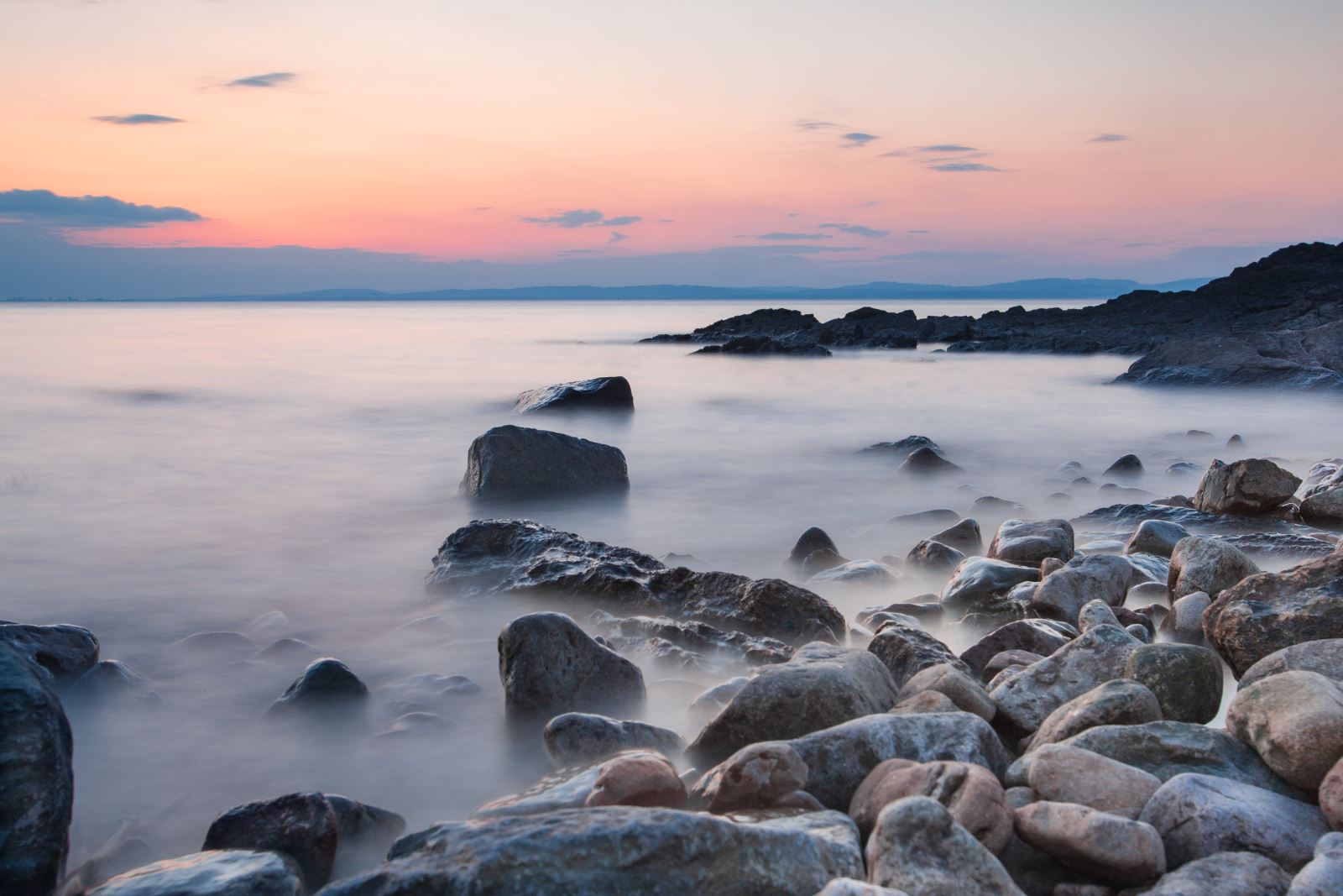 Waves wash over rocks at sunset