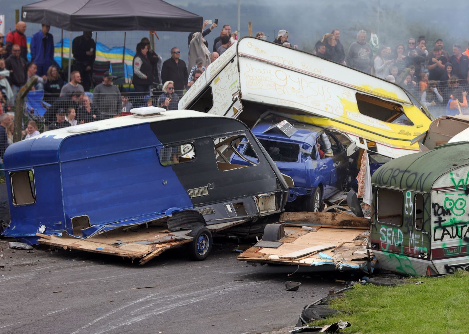 A banger racing smash at Mendips Raceway featuring two caravans and car which is stuck inside a caravan having crashed into it